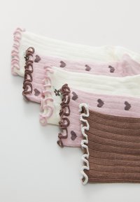 Vier Paare kniehoher Socken: in Creme, Rosa und Braun, mit einem strukturierten Strick, Rüschenspitzen und kleinen Herzmustern in kontrastierenden Farben.