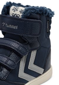 Granatowe sneakersy za kostkę z teksturowanej skóry, szare akcenty w zygzak, rzepy i puszysty kołnierz. Widoczne logo marki.