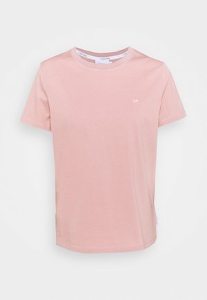 Camiseta de manga corta de color rosa claro de Calvin Klein con pequeño logo blanco "ck" en el pecho izquierdo y cuello redondo.