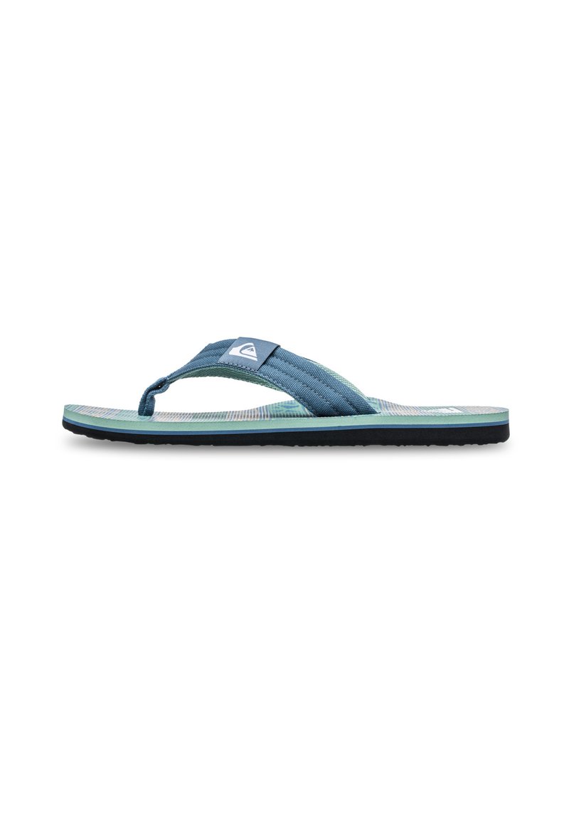 Blå stof flip-flop med tekstureret overflade, sort gummisål og kontrasterende grønne accenter. Har et logo på remmen.