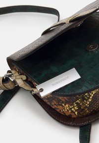 Torba na ramię z fakturowanej brązowo-zielonej skóry ekologicznej. Posiada złoty wzór akcentujący, srebrną metkę z logo oraz regulowany pasek.