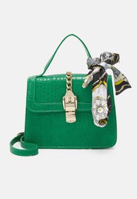 Borsa a tracolla in ecopelle di coccodrillo verde con una chiusura in metallo dorato, manico superiore e sciarpa decorativa in seta staccabile. Presenta una forma strutturata.