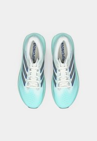 Αθλητικά παπούτσια σε ανοιχτό μπλε χρώμα με επάνω μέρος από διχτυωτό υλικό, λευκά κορδόνια και τρεις σκούρες μπλε ρίγες. Διαθέτουν στρογγυλεμένη μύτη και υφή στην σόλα.