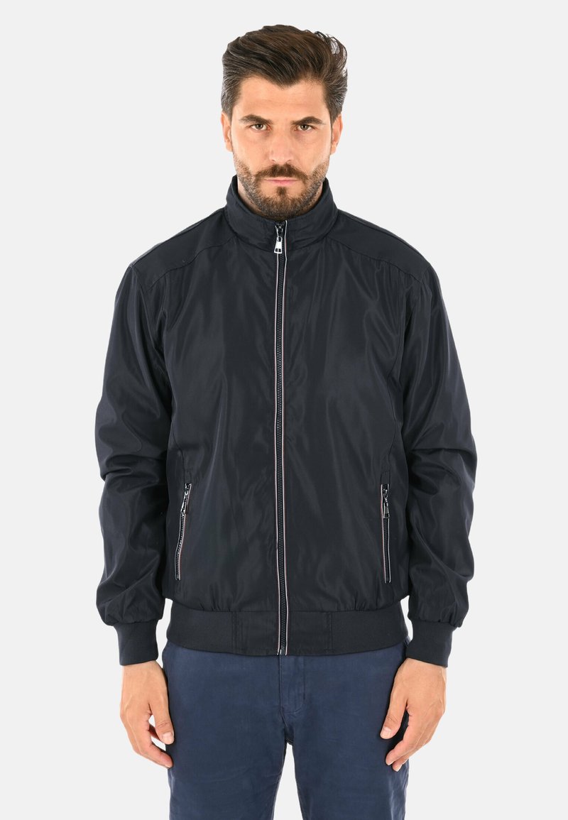 Giubbotto bomber nero con colletto alto, chiusura con zip sul fronte e tasche laterali. Presenta polsini e orlo elastici con una texture liscia e leggera.