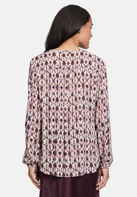 Blusa a maniche lunghe in tessuto leggero, con un motivo geometrico multicolore in malva, crema e blu, e un dettaglio plissettato sul retro.