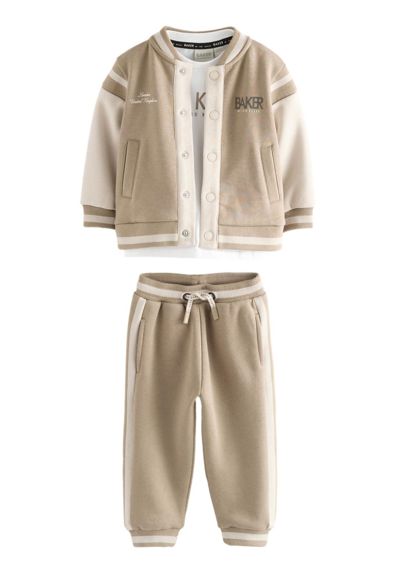 Ensemble sweat-shirt beige et pantalon de jogging assorti. Le sweat-shirt présente une ouverture à boutons, des accents de poches et des poignets rayés blancs. Mélange de coton doux.