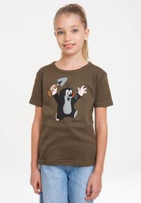 Camiseta de manga corta marrón con un dibujo de un topo sosteniendo una pala en colores vibrantes; material de algodón, corte relajado y escote redondo.
