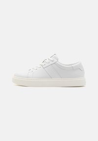 Sneaker in pelle bianca con texture liscia, punta tonda, design con lacci, branding minimalista e suola in gomma bianca a contrasto.