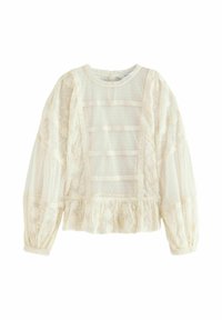 Blusa bianca in pizzo con maniche a sbuffo, orlo arricciato e pannelli trasparenti. Presenta motivi floreali e dettagli in pizzo orizzontali.