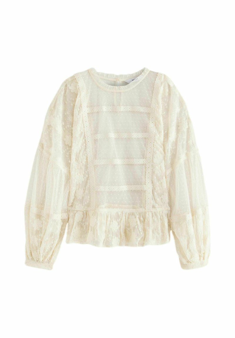 Blusa bianca in pizzo con maniche a sbuffo, orlo arricciato e pannelli trasparenti. Presenta motivi floreali e dettagli in pizzo orizzontali.