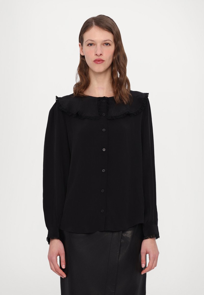 Black blouse with a ruffled collar, button-up front, long sleeves, and textured cuffs. Made from flowing fabric with a smooth finish.