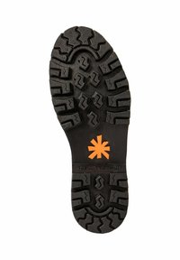 Suela de zapato de goma con surcos profundos para tracción, con un logo central de estrella naranja. Material negro texturizado, diseño robusto.