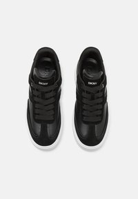 Black sneakers with suede and leather upper, featuring black laces, DKNY logo on the tongue, and a white rubber outsole.