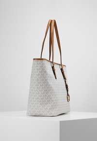 Tasche aus weißem strukturiertem Stoff mit einem sich wiederholenden Logo-Muster, braunen Lederriemen und goldenen Hardware-Details. Seitenansicht dargestellt.