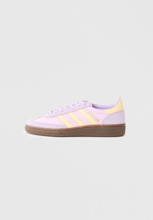 Niskie buty sportowe Adidas w pastelowym fioletowym i żółtym kolorze z gumową podeszwą, trzema paskami po bokach i złotym logo "Spezial".