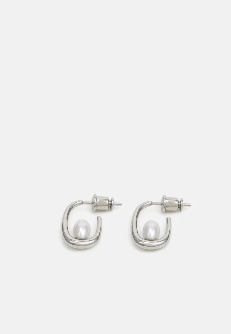 Sølvfargede metalløreringer med et sirkulært design og en fremtredende hvit perle i midten. Glatt overflate, minimalistisk stil.