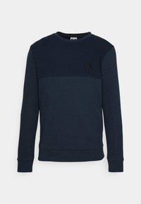 Sudadera azul marino con un panel superior texturizado, puños y dobladillo acanalados, con un acento de logo negro en el pecho. Material suave, similar al algodón.