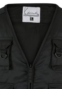 Crna zip-up prsluk napravljen od izdržljive tkanine, s V-izrezom, dva prednja džepa s preklopima i metalnim detaljima. Veličina L.