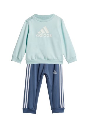 Sudadera azul claro con el logo blanco de "adidas" y broches en los hombros, combinada con pantalones de chándal azul marino que tienen rayas blancas y el logo en el tobillo.