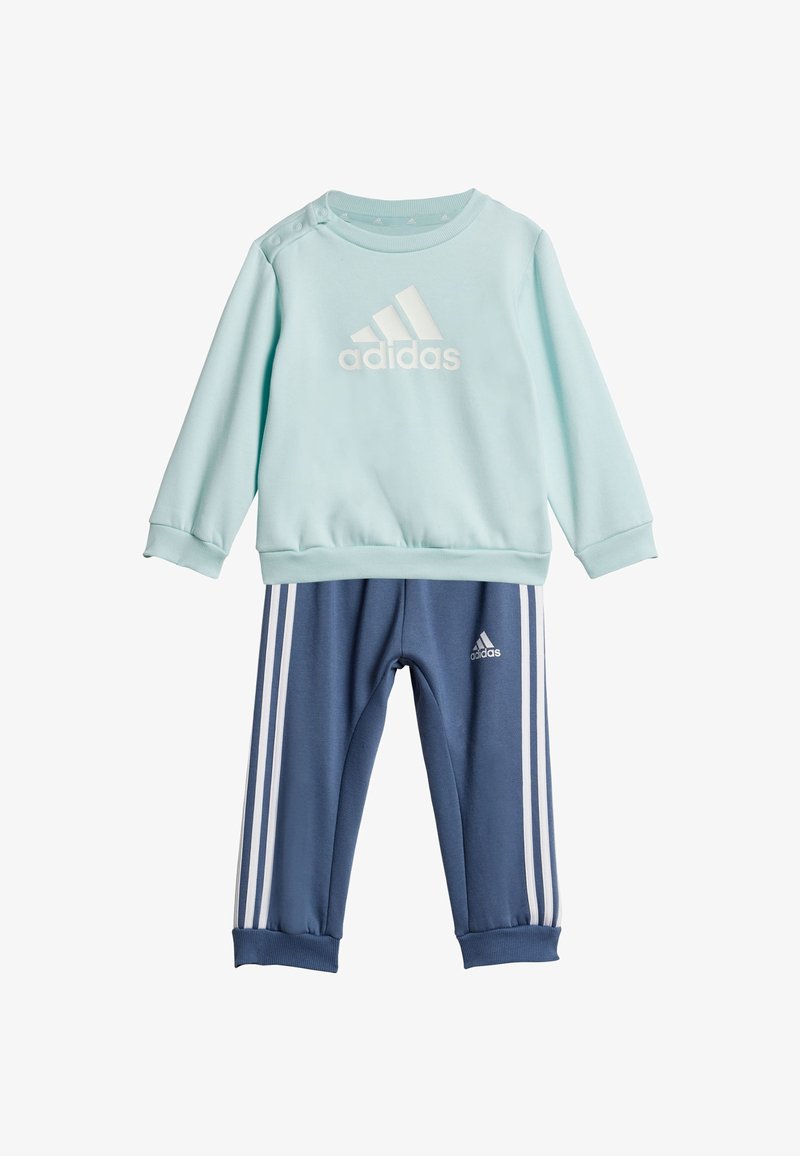 Sudadera azul claro con el logo blanco de "adidas" y broches en los hombros, combinada con pantalones de chándal azul marino que tienen rayas blancas y el logo en el tobillo.