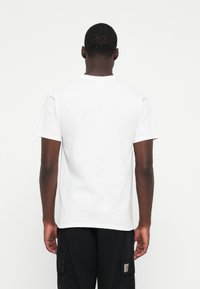 White cotton t-shirt with short sleeves and a crew neck, displayed from the back, featuring a plain design and a relaxed fit.