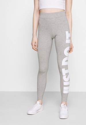 Szare legginsy wykonane z dzianiny bawełnianej z wysokim stanem, z dużym białym nadrukiem "JUST DO IT" wzdłuż boku.