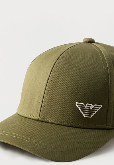Καπέλο μπέιζμπολ σε ελαιί απόχρωση με καμπύλη γείσα και λευκό κεντημένο λογότυπο στο μπροστινό δεξί πάνελ, σε απλό φωτεινό φόντο.