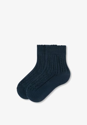 Paire de chaussettes bleu foncé montant à la cheville avec un motif tricoté texturé et des bordures côtelées, présentée sur un fond blanc.