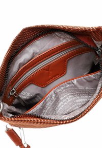 Oranža modeļa somiņa ar rāvējslēdzēju un teksturētu ārpusi. Iekšpusē pelēks auduma oderējums, viena kabata ar rāvējslēdzēju un kartes turētāji.