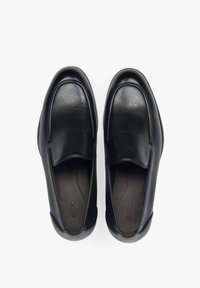 Zwarte leren instapschoenen met een ronde neus, een glad oppervlak, minimale stiksels en een gevoerde binnenzool. Vlakke rubberen zool.