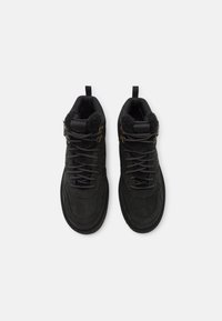 Czarne, sięgające kostki buty z miękkiego zamszu o teksturowanej powierzchni, z zaokrąglonym noskiem, sznurowanym designem i wyłożonym futrem kołnierzem.