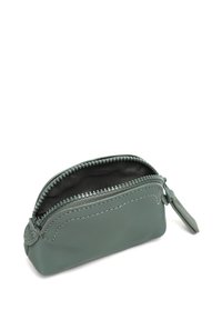 Groene lederen zak met een zwarte binnenkant, ritssluiting en contrasterende witte stiksels. Voorzien van een kleine aan de rits bevestigde trekker.