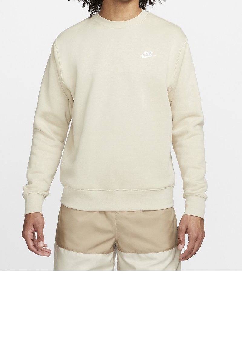 Beige Nike sweatshirt med rund halsringning, långa ärmar, ribbade mudd och broderad logotyp på bröstet; jämn textur och avslappnad passform.