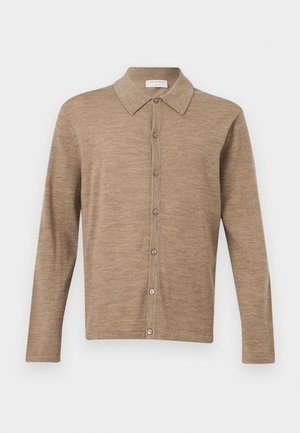 Beige cardigan met lange mouwen en knopen, voorzien van een kraag, gemaakt van zacht gebreide stof, weergegeven op een effen witte achtergrond.