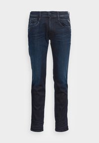 Dark blue denim jeans with a tapered fit, five pockets, and contrast stitching. Features a button and zipper closure. Smooth texture.