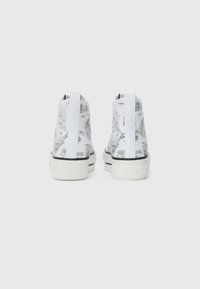 Høye sneakers med hvitt stoff, med et svart og grått bylandskapstrykk. Gummisåle med svart stripe og preget merke logo.