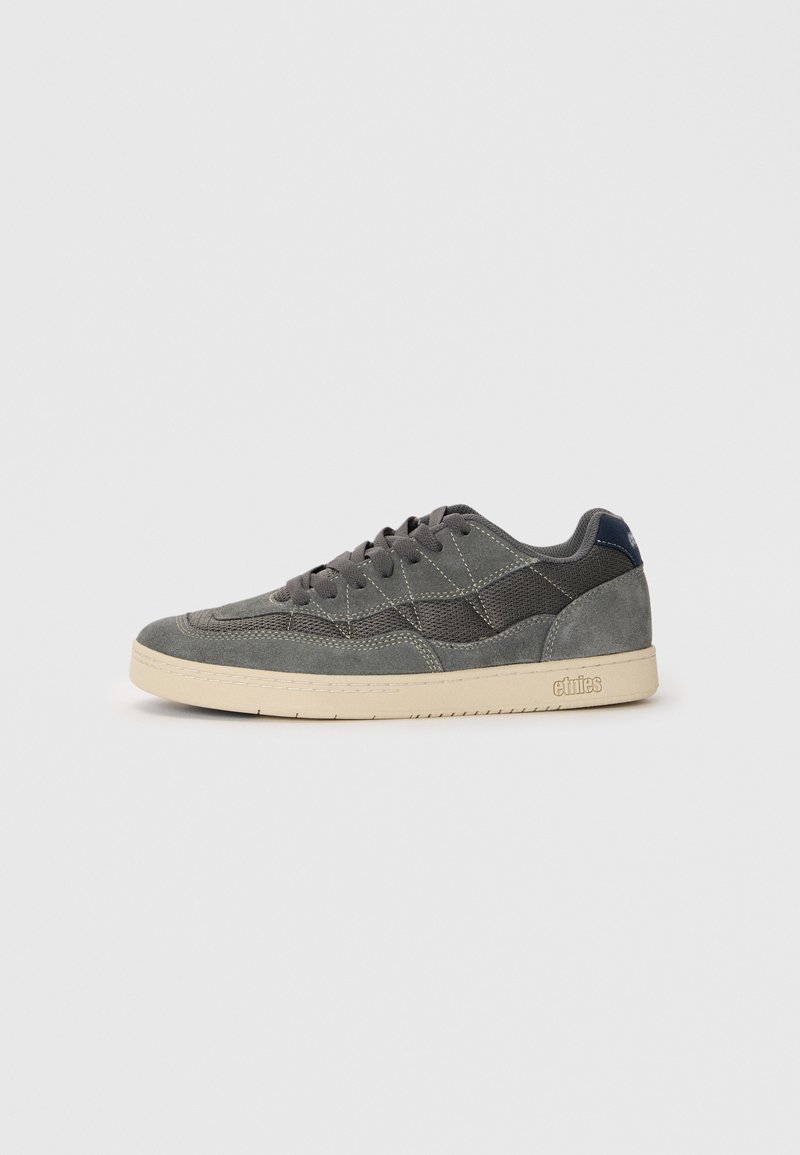 Gray suede and mesh sneaker with beige rubber sole, featuring tonal stitching, a low-top design, and a small logo on the heel.