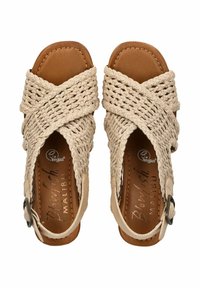 Beige tkané sandály s kříženými pásky a hnědou faux kůží na vnitřní podrážce. Mají nastavitelné sponky a logo "Blowfish Malibu".
