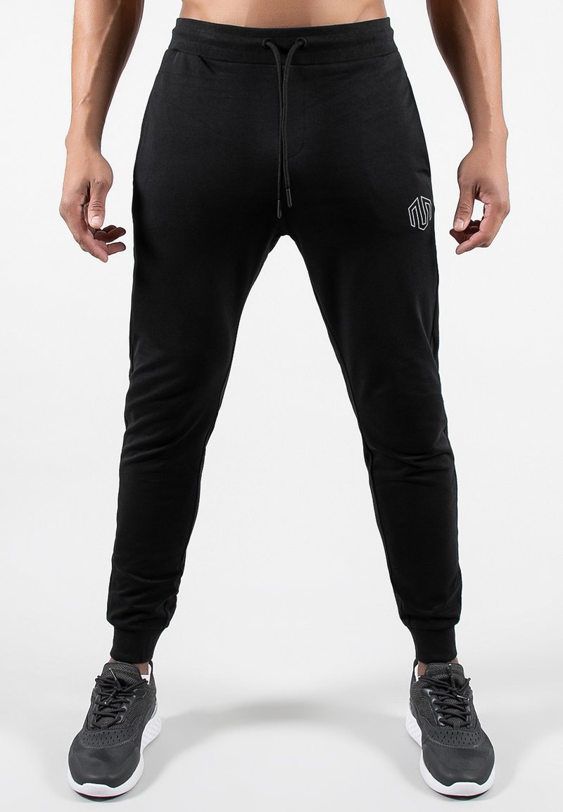 Pantaloni da jogging neri realizzati in tessuto morbido, con vita regolabile tramite cordoncino, design a gamba affusolata e un logo discreto sul lato sinistro.