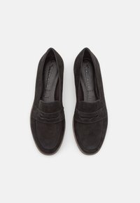 Paire de mocassins noirs en daim à enfiler avec des talons bas et des bandes décoratives sur le devant, vus de dessus sur un fond blanc.