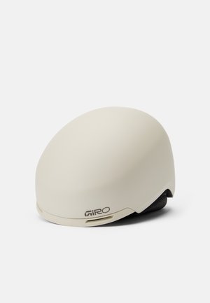 Giro-Helm in mattem Cremefarben, runder Form mit glatter Oberfläche. Verfügt über seitliche Lüftungsöffnungen und weiche Innenpolsterung. Logo auf der Vorderseite gedruckt.
