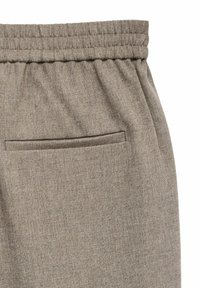 Pantaloni in tessuto beige con cintura elastica e una singola tasca posteriore orizzontale cucita e chiusa.