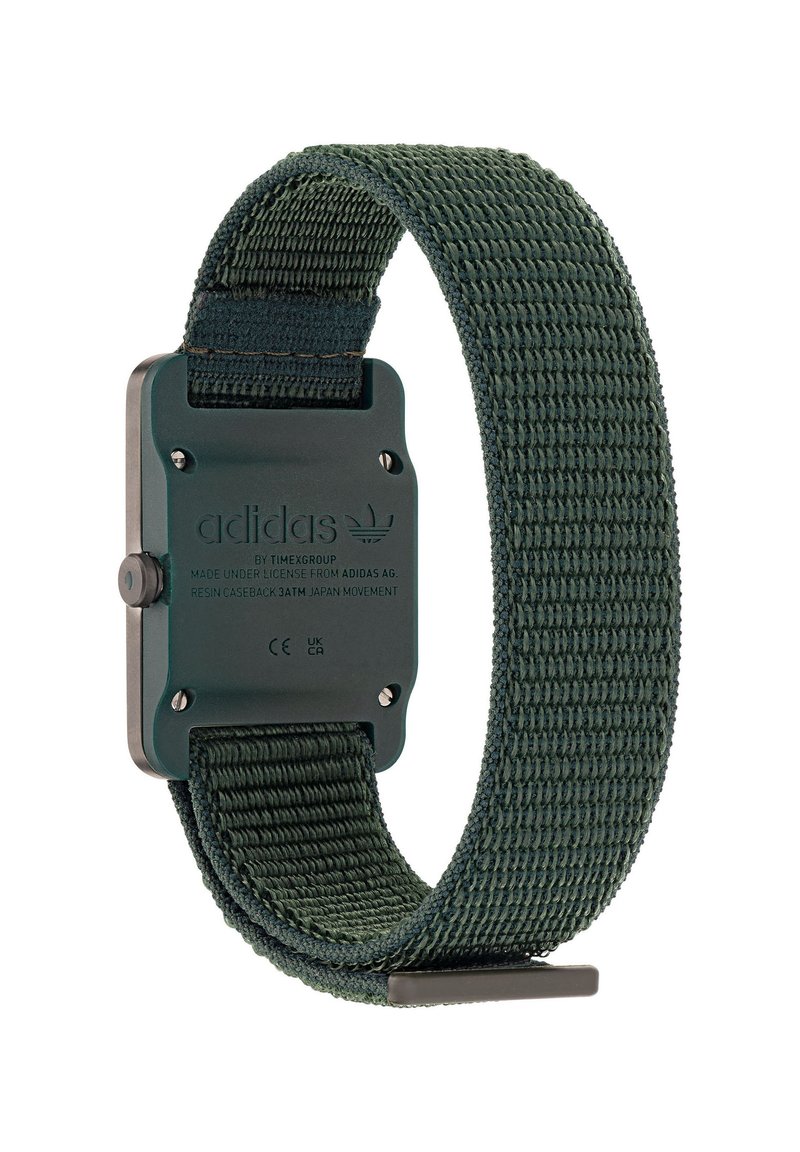 Montre Adidas avec un bracelet en nylon tissé vert foncé et un fond de boîtier rectangulaire noir présentant les détails de la marque et de la fabrication.