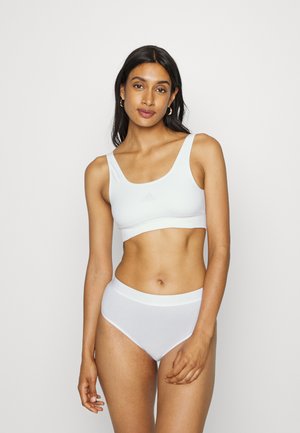 White cotton sports bra with wide straps and a scoop neck, paired with matching high-waisted underwear featuring a logo waistband.