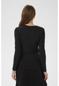 Fekete, hosszú ujjú felső, testhezálló szabással, puha textúrával és kerek nyakkivágással. Finom csillogás díszíti az anyagot.