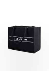 Černá obdélníková látková taška s dvěma ušima, která má bílé logo "CARLHEIM" a dvě vodorovné bílé pruhy.