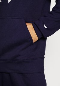 Fanatics MLB NEW YORK YANKEES ESSENTIALS CREST GRAPHIC HOODIE - Kapuutsiga pusa - navy
