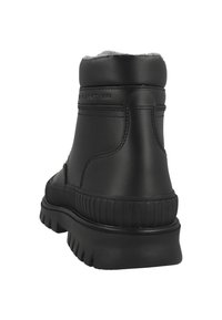 Black high-top winter boot with thick textured sole and fleece lining, stitched detailing, viewed from the back.