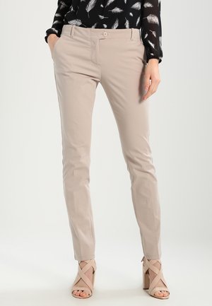 Beige Hosen aus glattem Stoff mit slim fit, ausgestattet mit einem frontalen Knopfverschluss und seitlichen Taschen. Kombiniert mit beigen Sandalen mit Riemchen.