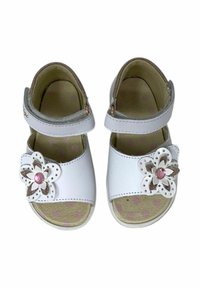 Sandali bianchi con punta e tallone aperti, cinturino regolabile, dettaglio floreale con un gemma rosa, e soletta beige testurizzata con pois rosa.